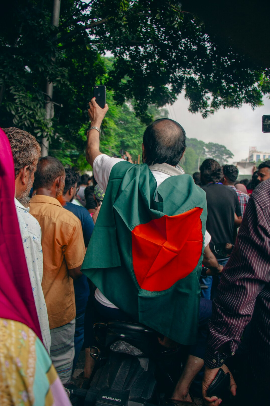 Diverse group of Malaysian professionals celebrating outdoors with raised arms